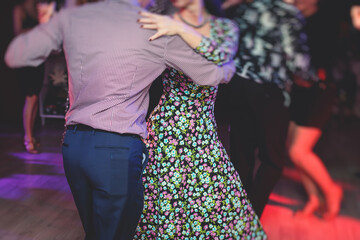 Couples dancing traditional latin argentinian dance milonga in the ballroom, tango salsa bachata kizomba lesson in the red lights, dance festival