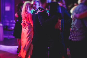 Couples dancing traditional latin argentinian dance milonga in the ballroom, tango salsa bachata kizomba lesson in the red lights, dance festival