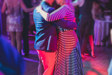 Fototapeta na wymiar Couples dancing traditional latin argentinian dance milonga in the ballroom, tango salsa bachata kizomba lesson in the red lights, dance festival