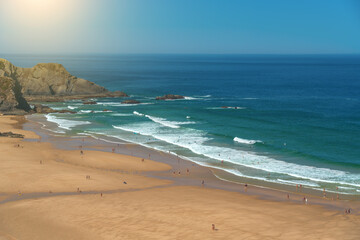 Delightful panoramic view of the Portuguese beach Odeceixe with tourists at the sea.