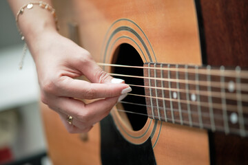 Fototapeta premium girl's hands playing an acoustic guitar