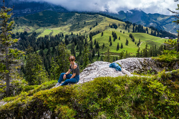 Naklejka na ściany i meble Young girl in the mountains. Alpine expanses. Freedom and space all around.