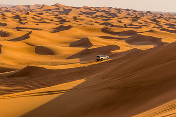 A lone vehicle on a desert safari in the red desert at Hatta near Dubai, UAE in springtime
