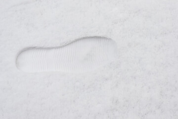 Close-up of a boot print in the snow