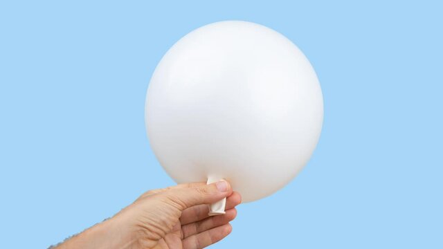White balloon being blown up against blue background