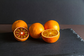 Four blood oranges, one halved.
