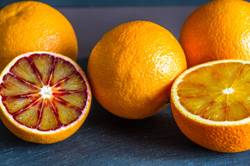 Four blood oranges, one halved.