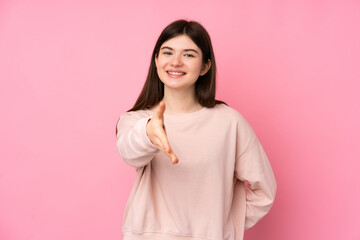 Young Ukrainian teenager girl over isolated pink background shaking hands for closing a good deal
