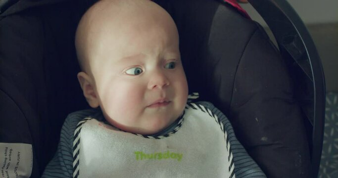 Perplexed baby boy with blye eyes lying, crying and looking into camera