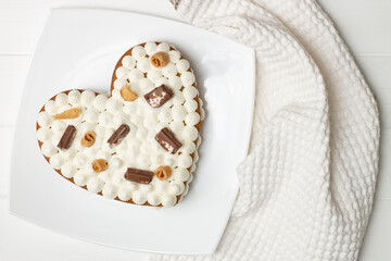 Step-by-step heart-shaped cake recipe instructions. Step 12: Decorate with chocolate, waffles, cookies, flat lay.