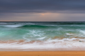 Low cloud filled sky and sunrise seascape