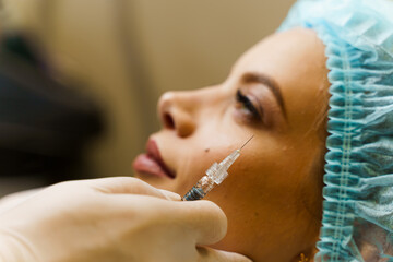 Close-up filler injection in cheekbones. ?ontour plastic for correcting the volume and shape of the nose, chin, cheekbones, temples. Cosmetic rejuvenating facial treatment.