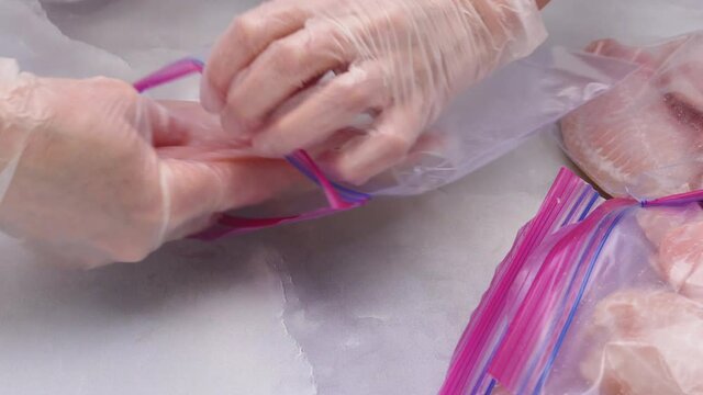 Fresh raw fish fillet in zip lock bags. Tilapia fillet on light marble background, close up