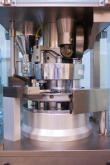 Drug tablet and pill rotary press machine in in the lab ore medicine manufacturing factory health and hospital background concept. Рharmaceutical laboratory.