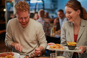 Couple sitting in restaurant, eating diner and drinking wine.