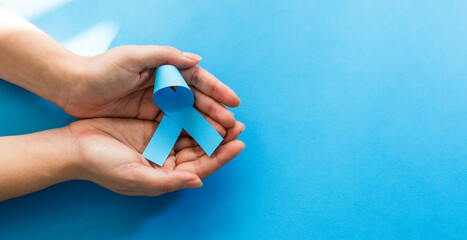 Woman hands with blue ribbons, Prostate Cancer Awareness. Male Health Care Concept.