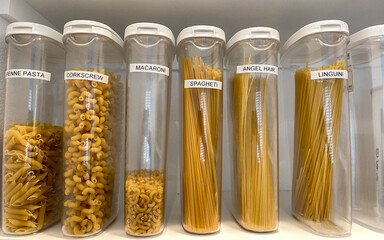 An organized pantry shelf with various types of pasta