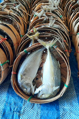 Steamed mackerel in a bamboo basket, a close-up view.