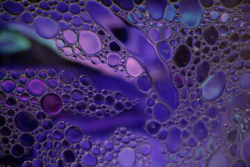 Purple, Blue and Turquoise Oil and Water Abstract Photo. Different sized circles of orange purple and green. Beautiful abstract background wallpaper.
