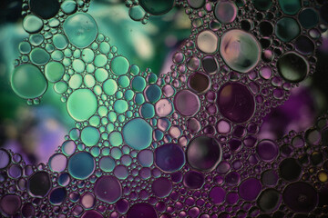 Purple, Blue and Turquoise Oil and Water Abstract Photo. Different sized circles of orange purple and green. Beautiful abstract background wallpaper.