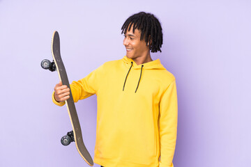 Handsome young skater man over isolated wall with happy expression