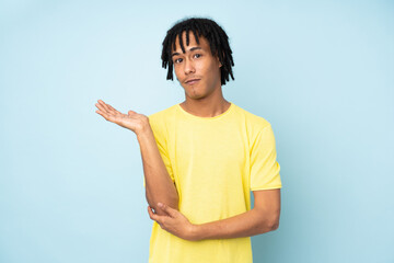 Young african american man isolated on blue background unhappy for not understand something