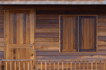 Front view of wooden door and window with porch railing made from recycled old wood panels, reuse and upcycle concept