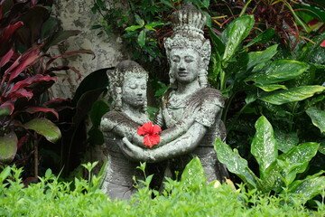 Indonesia Bali - Ubud Handmade stone statues with red Hibiscus flower