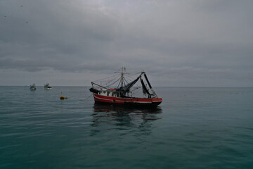 Obraz premium Aerial view of a medium sized fishing boat towards the shoreline of Puerto lopez