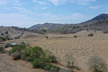 Aerial view over a farm with dry land that is covered in yellow sand