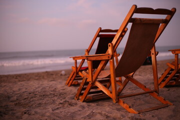 Two relaxing chairs on the beach with a warm coloration of the sunset