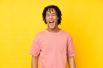 Young african american man isolated on yellow background shouting to the front with mouth wide open