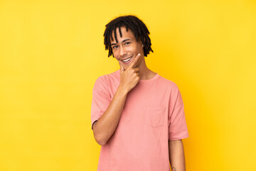 Young african american man isolated on yellow background smiling