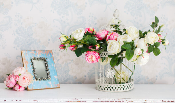 Decorative cell with tender flowers near vintage wooden blue frame