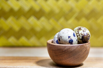 Three Quail Eggs In A Small Wooden Bowl on a Kitchen Counter Top