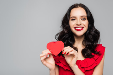 happy young woman holding red paper heart isolated on grey
