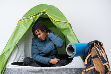 Young african american man inside a camping green tent with neckache