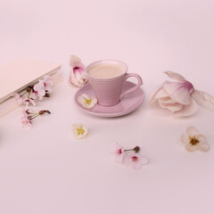 Fototapeta na wymiar beautiful tender still life, card on a beige background, magnolia buds, a cup of cappuccino, concept of a floral spring background