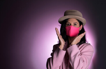 Young woman wearing medical face mask, studio portrait. 