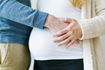 Husband and wife holding pregnant belly bump