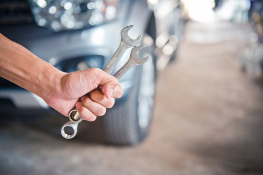 person holding a wrench, for repair a car