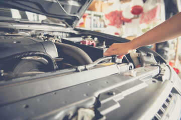 A man checking the auto engine, uses a wrench to fix the car engine,repair service