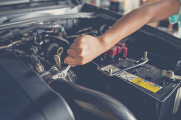 A man checking the auto engine, uses a wrench to fix the car engine,repair service