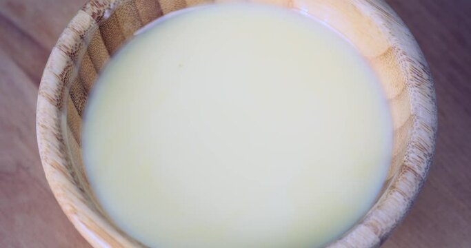 Pouring of sweet condensed milk in bowl, closeup
