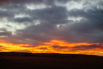 Fototapeta na wymiar Fiery scenic sunset sky in blue and bright orange colors