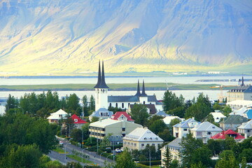 The buildings and residential area in the city on a bright summer evening near Reykjavik, Iceland - obrazy, fototapety, plakaty