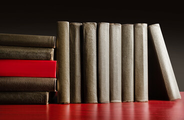 Photo of an old antique books standing and laying on table surface.