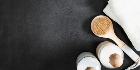 Bathroom decor in white and black color, towel, soap dispenser, accessories on dark background. Elegant decor bathroom interior. Flat lay, top view, copy space
