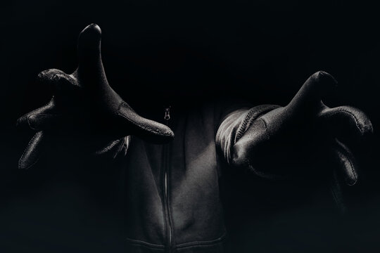Horror photo of a scary man hands reaching out from darkness with fog.