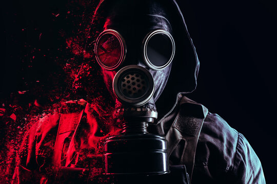 Photo of a stalker face in soviet old gas mask with filter and red highlights dissolving on black background.